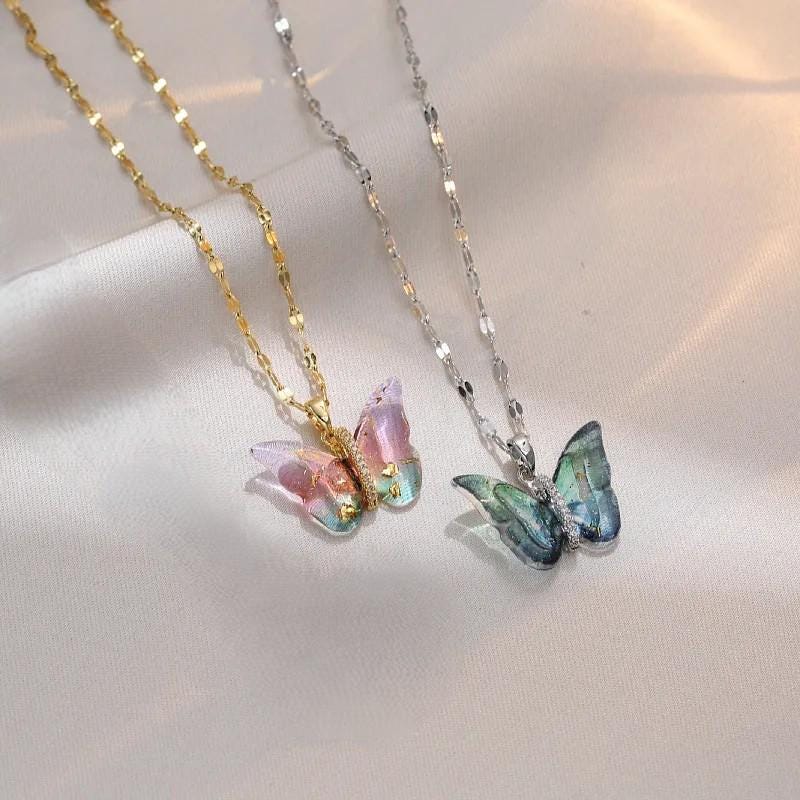 Collar con colgante de mariposa, en dorado y plateado.