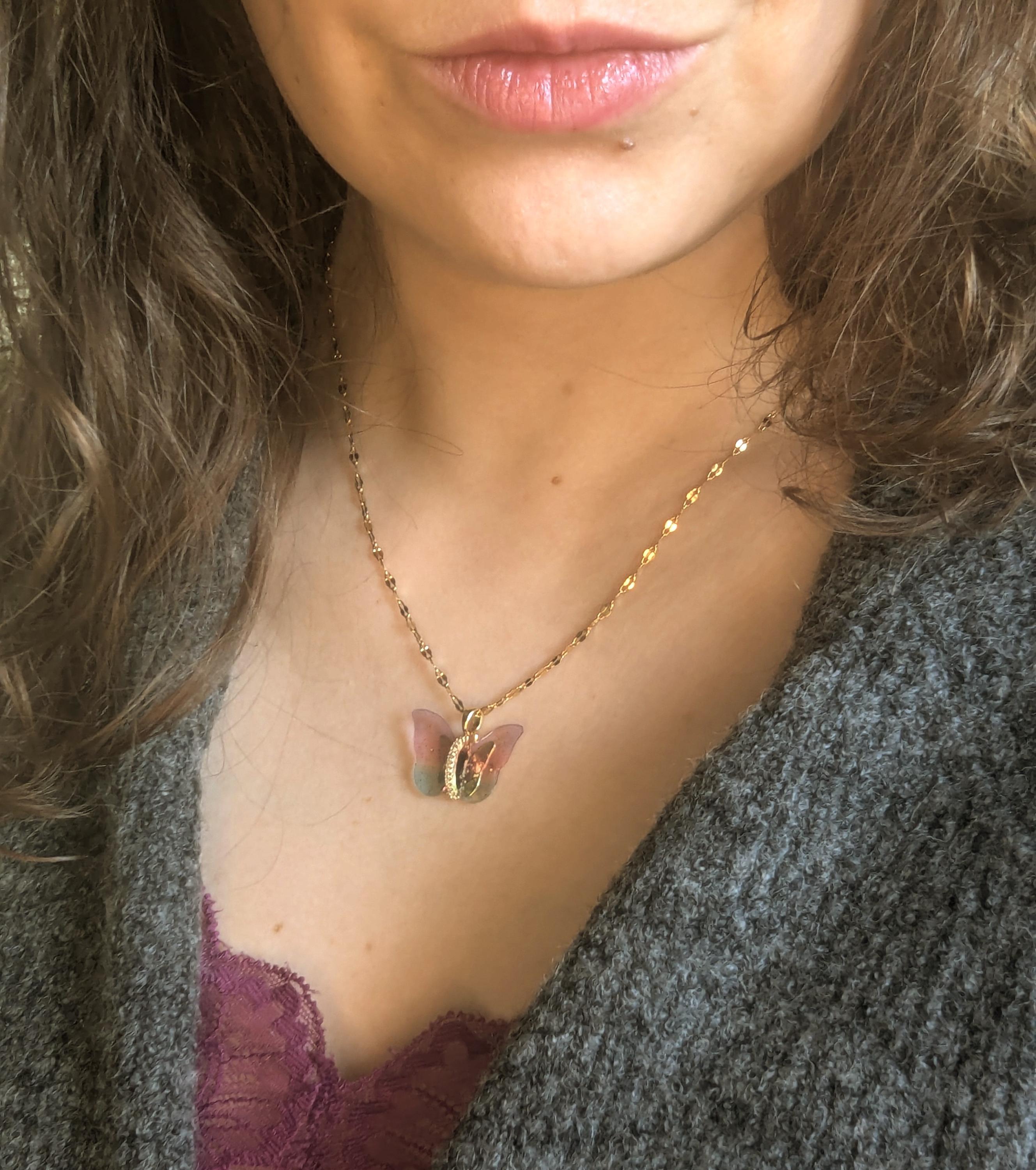 Collar con colgante de mariposa, en dorado y plateado.