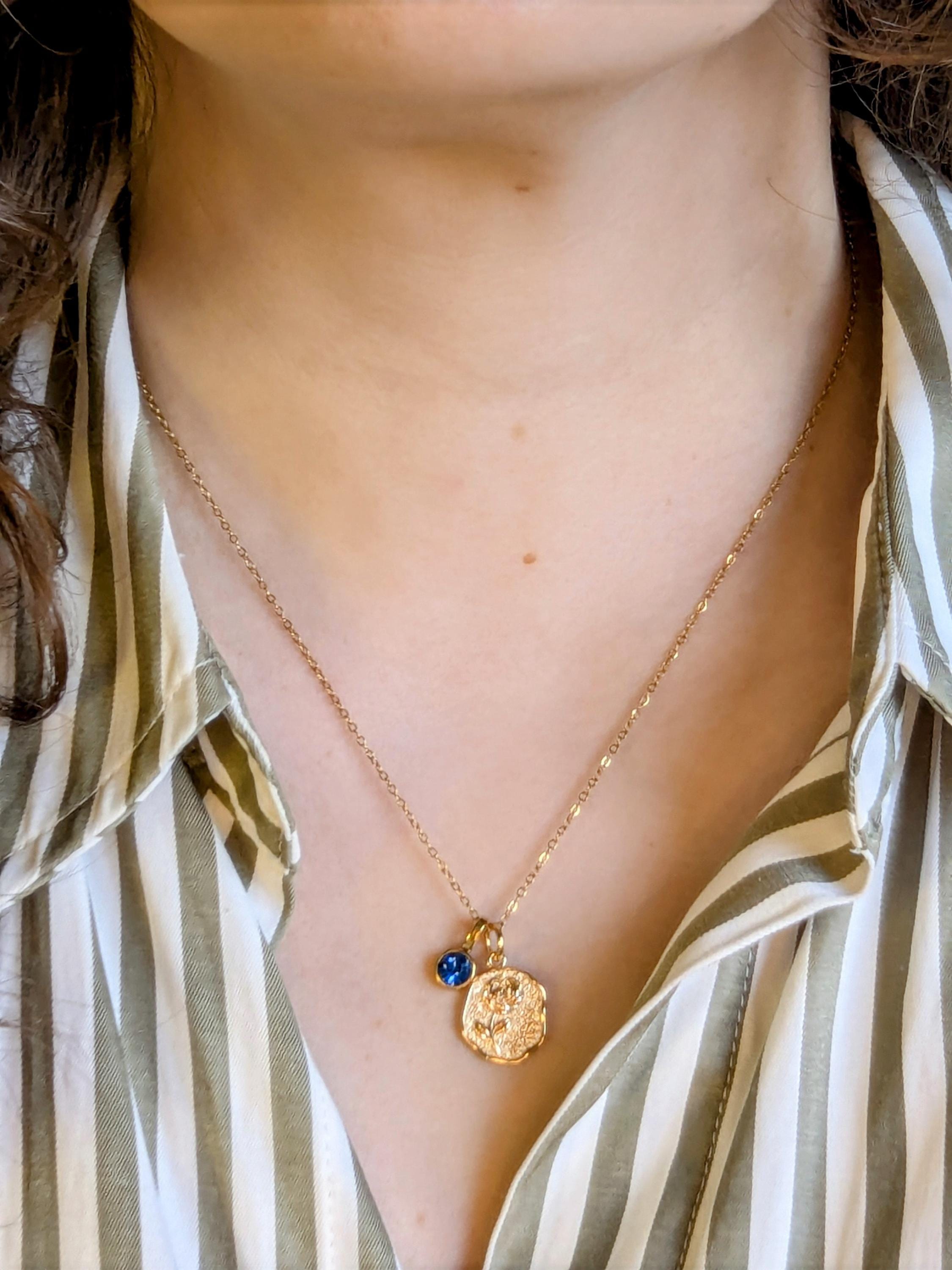 Collar con piedra de nacimiento, en color dorado.